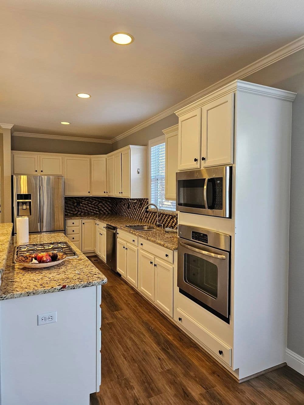 Modern kitchen with white cabinets, stainless steel appliances, and granite countertops.